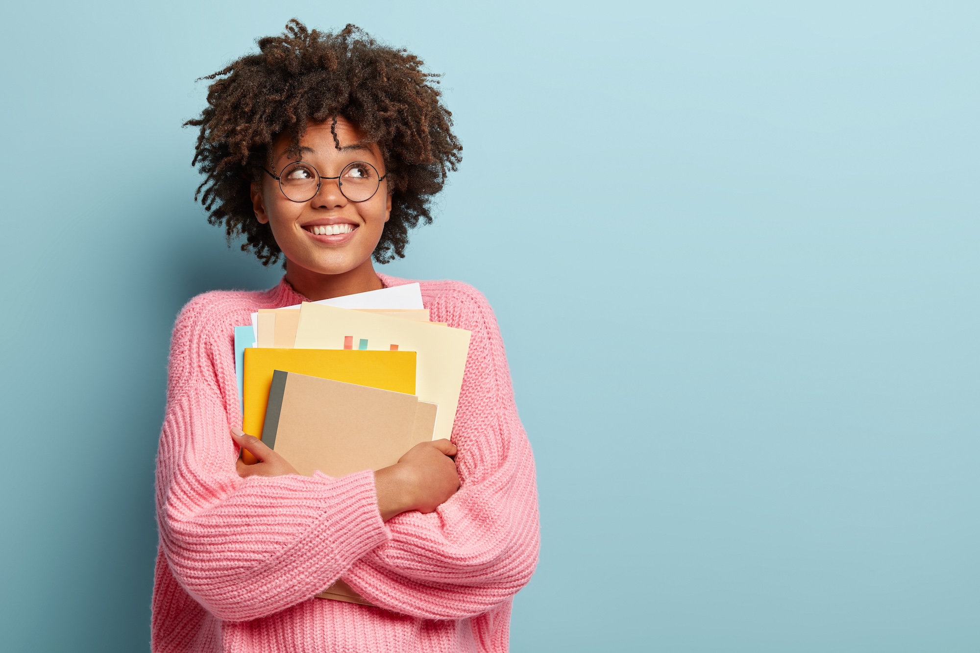 Student smiling while holding books