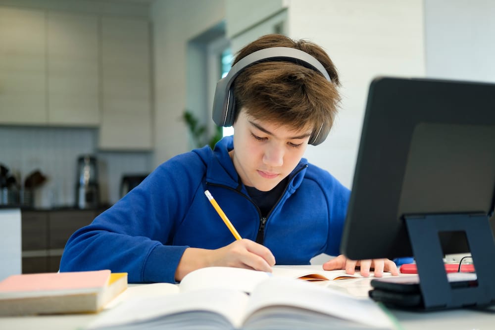 Student focused on schoolwork with headphones